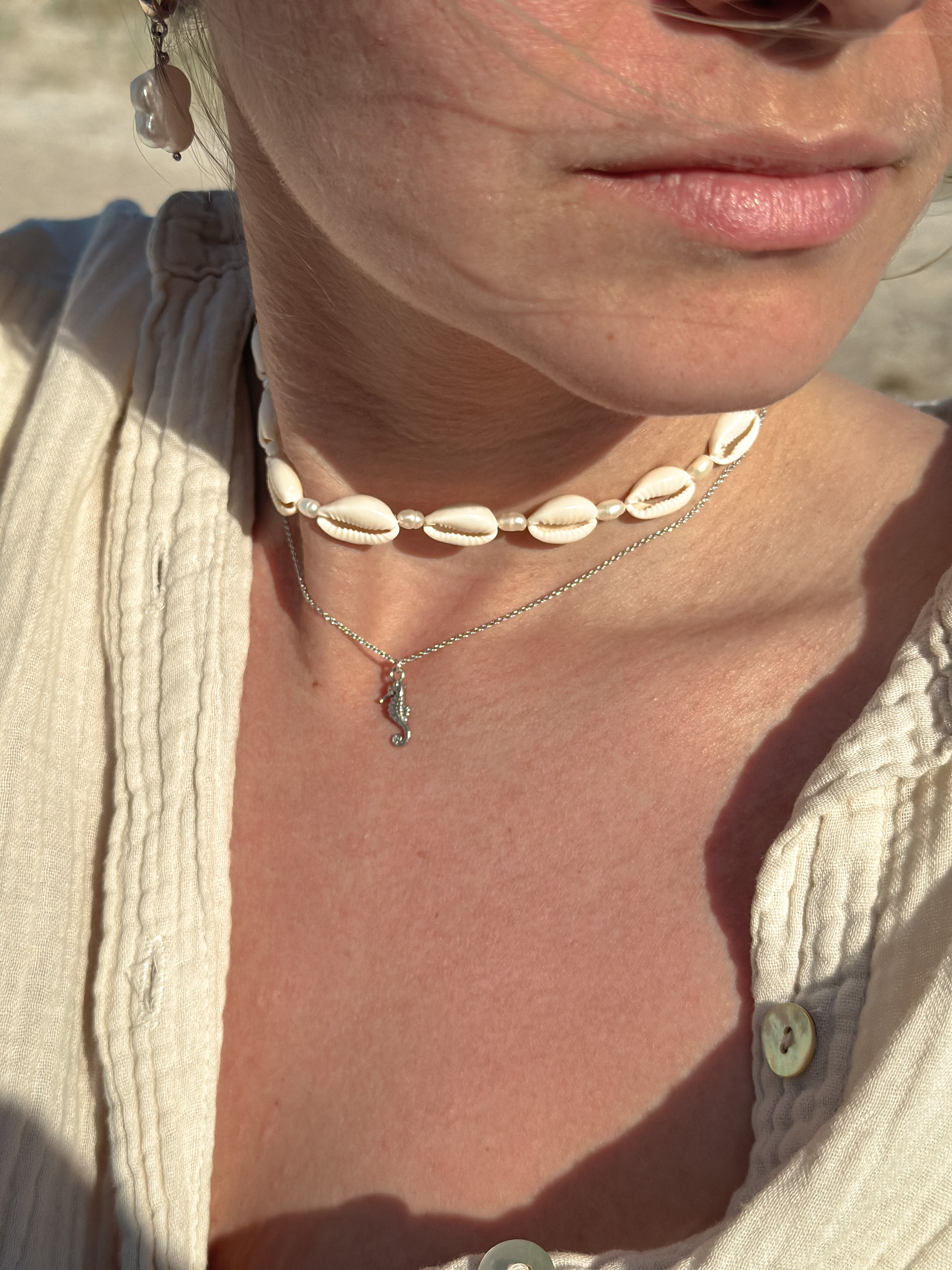 Frau mit Kaurimuschel Kette