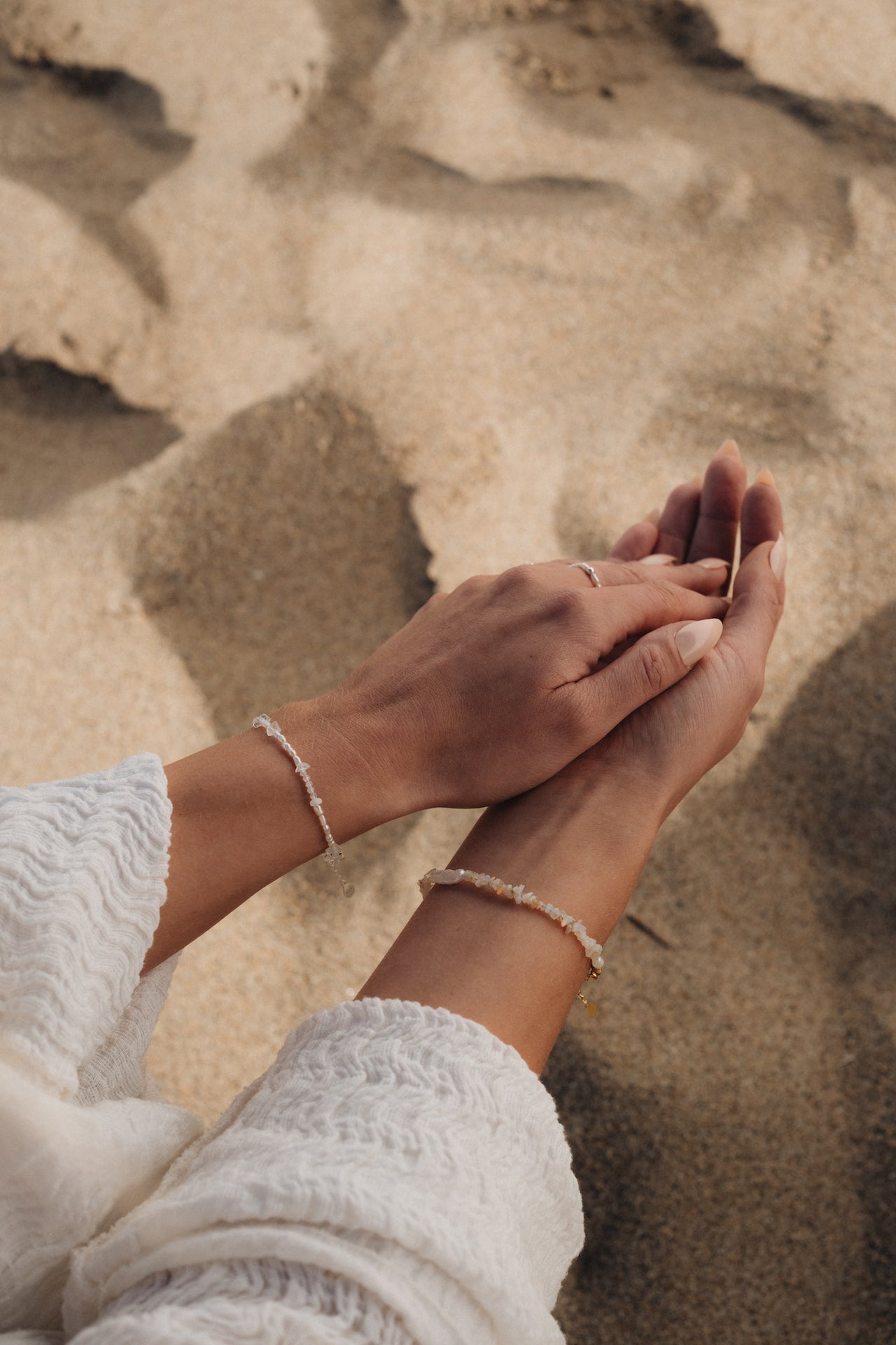 Armband aus Opalsteinen TRANSLUCENT SEA über Strandsand getragen
