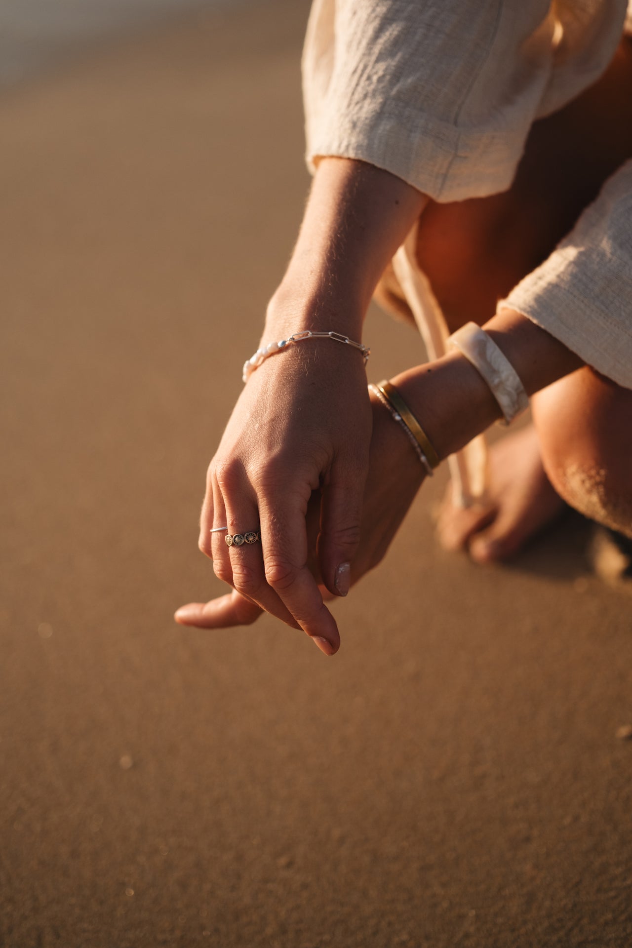 Armband mit Süßwasserperlen KESHI DREAM getragen am Handgelenk über Sand am Strand