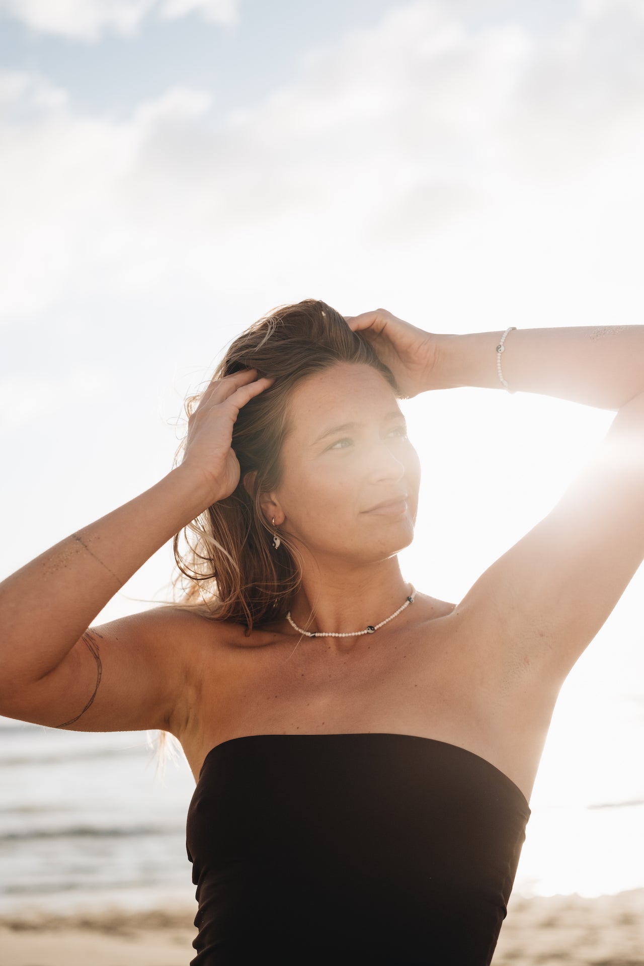 Creolen Ohrringe BALANCE SEA Tragefoto mit Sonne im Hintergrund