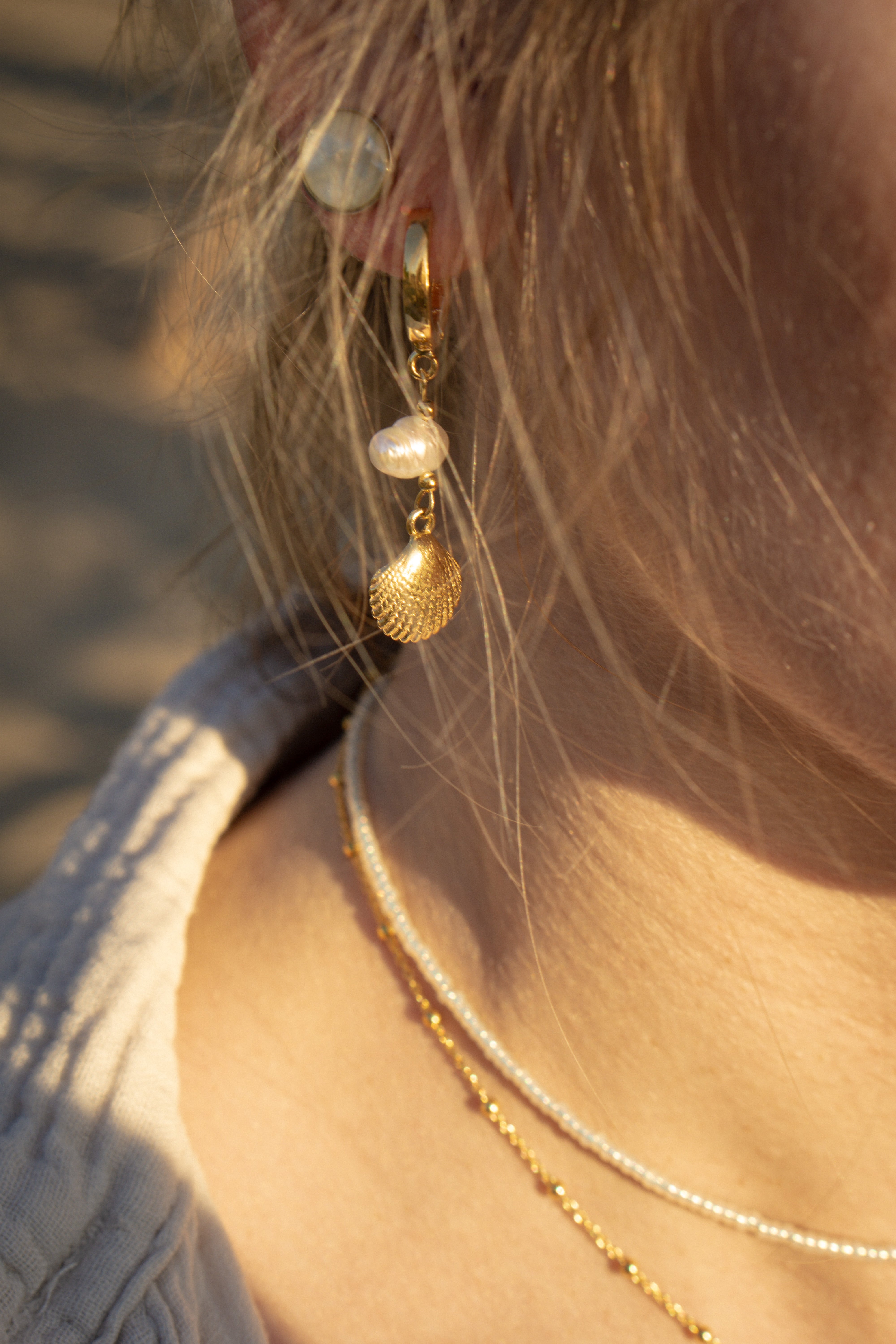 Creolen Ohrringe mit Muschelanhänger MAGIC SEA in Nahaufnahme am weiblichen Model