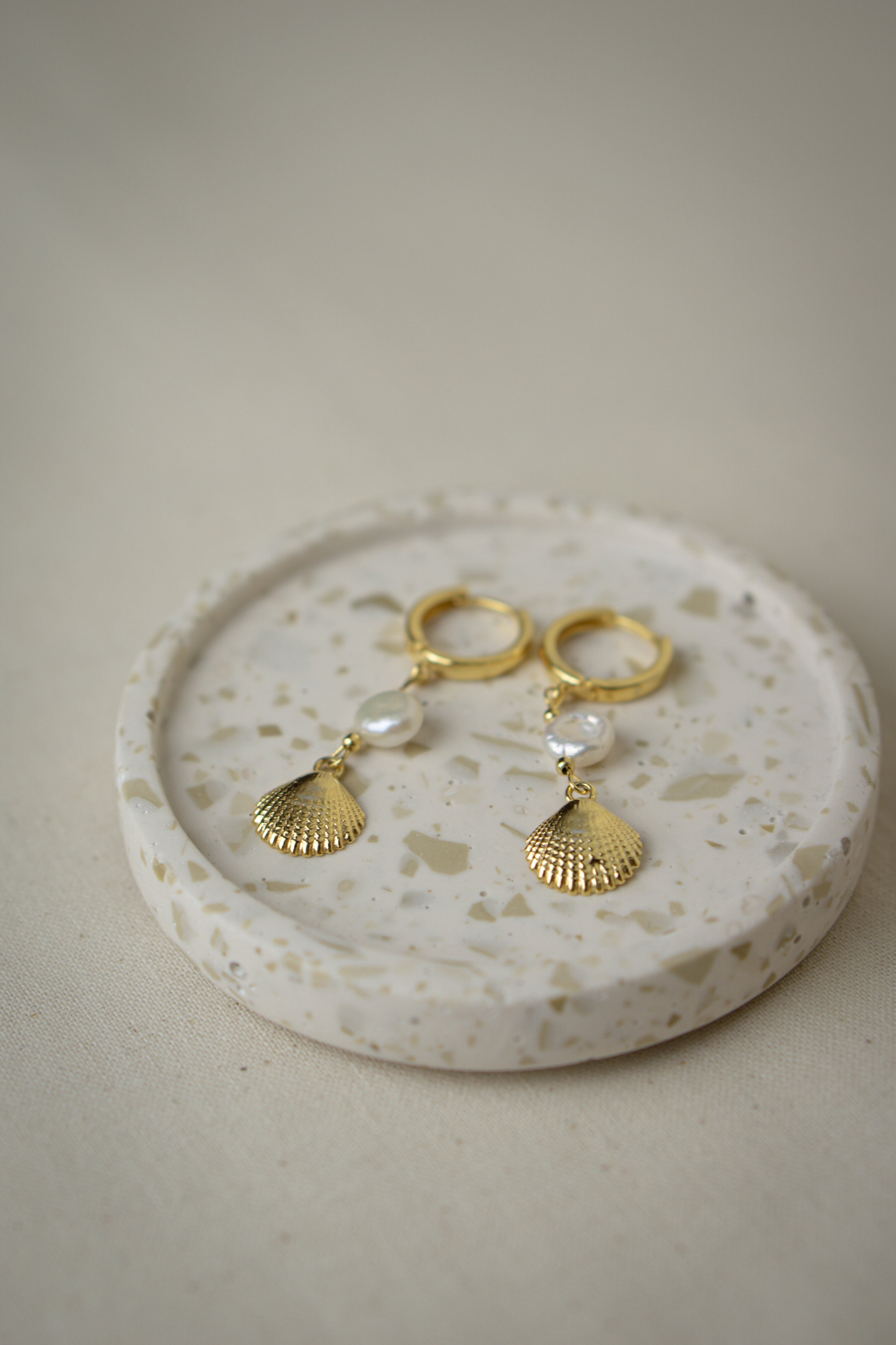 Creolen Ohrringe mit Muschelanhänger MAGIC SEA liegend in Keramikschale