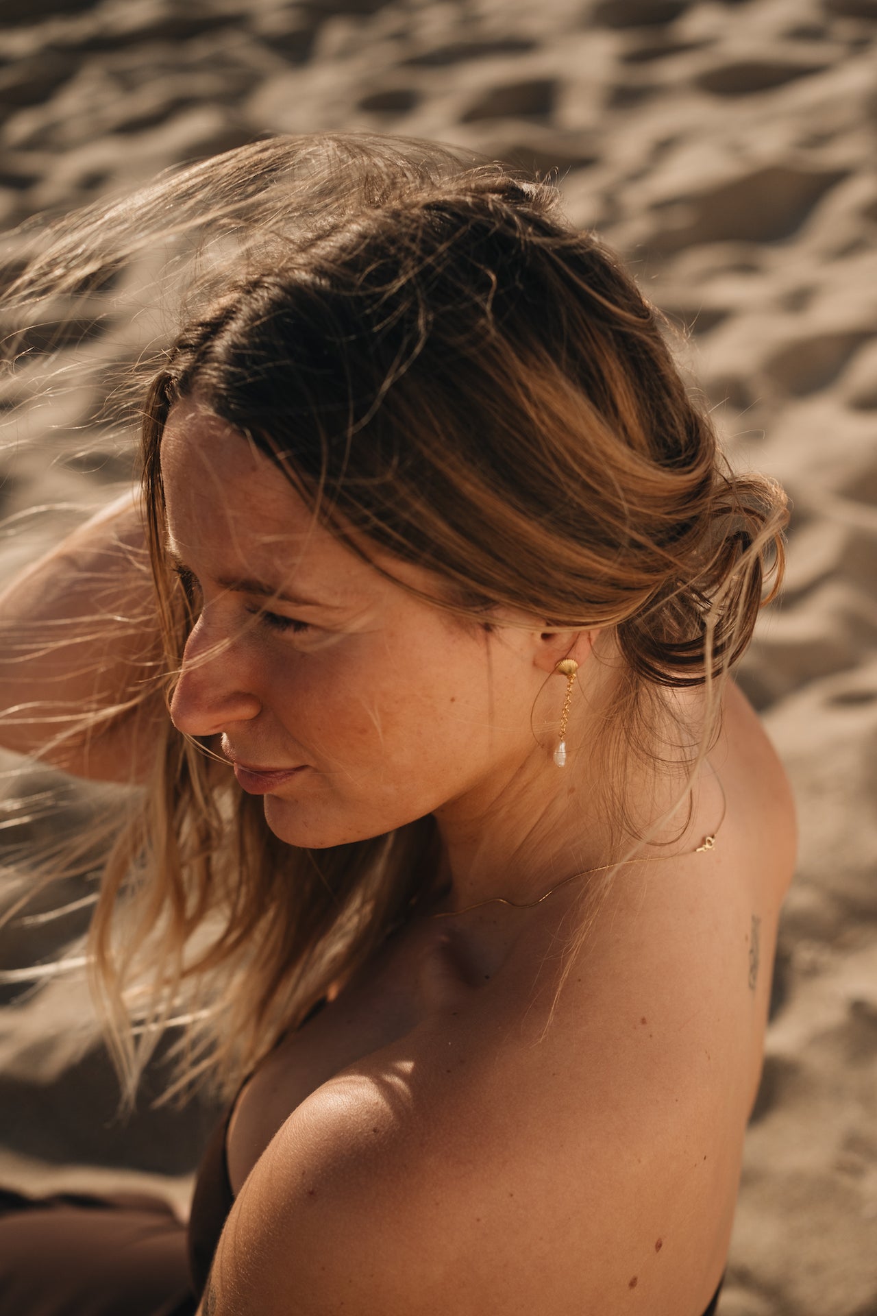 Ohrstecker UNDERWATER LOVE in gold getragen von Model am Strand
