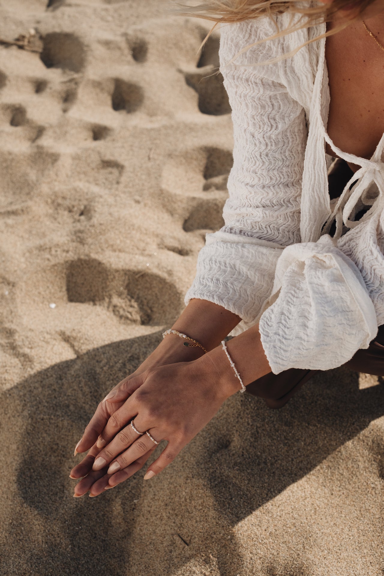 Perlenarmband BLUE MOON Tragefoto am Handgelenk mit Händen über Sand