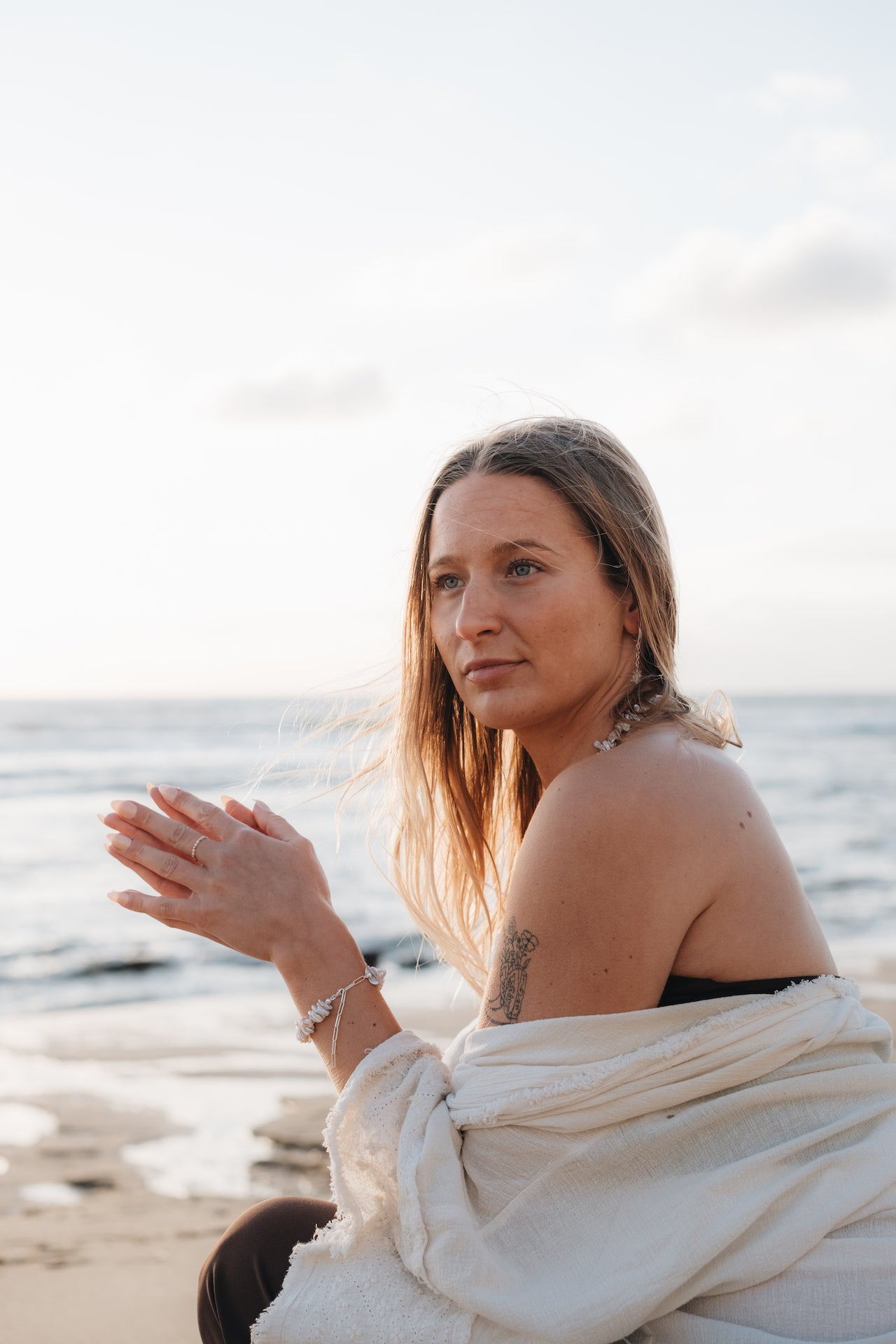 Perlenarmband HAWAIIAN DREAM getragen von Model am Meer in achtsamer Pose
