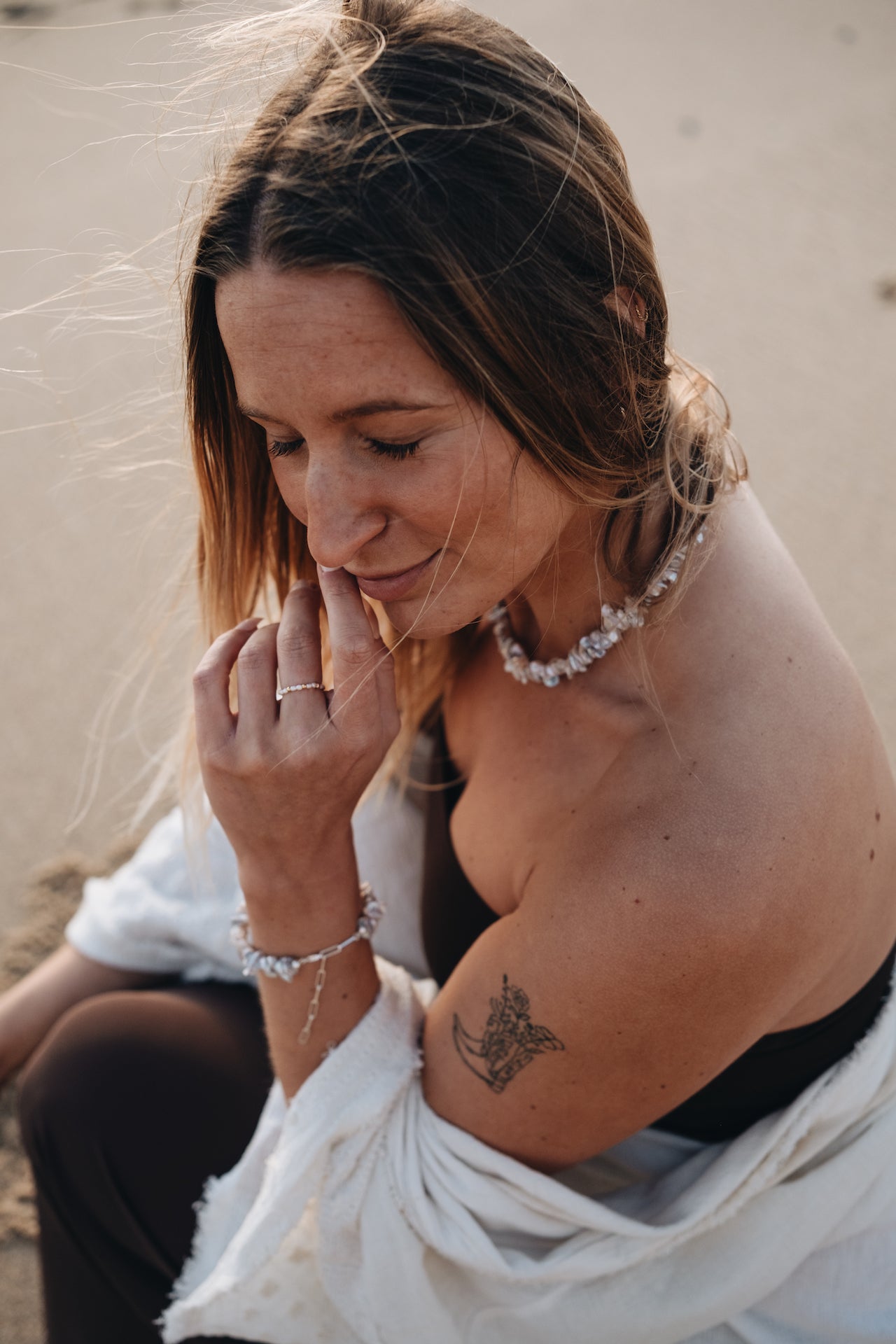 Perlenarmband HAWAIIAN DREAM getragen von schmunzelnder Frau am Strand