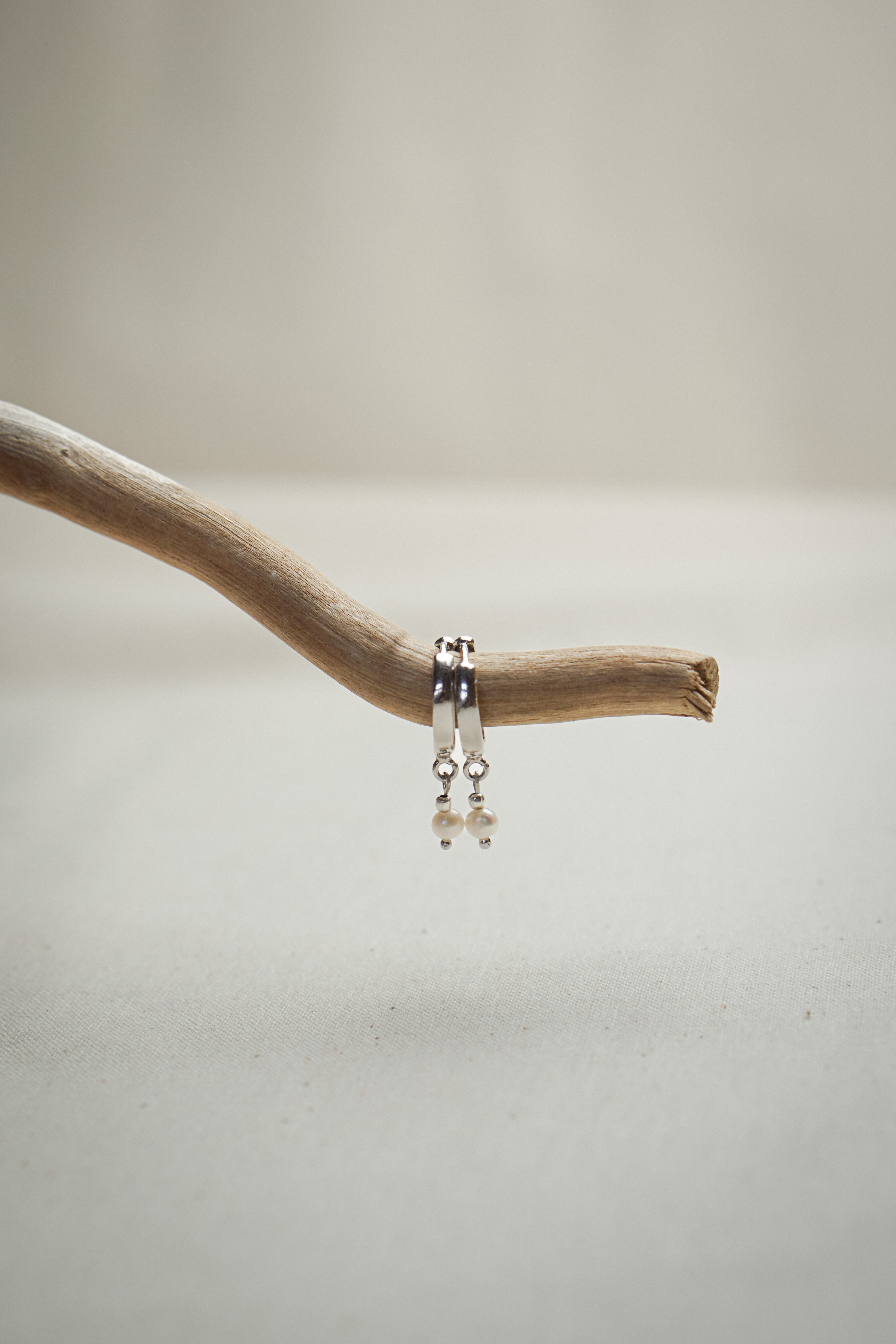 Creolen Ohrringe mit Perle SOUL OF THE SEA hängend auf Treibholz in silber