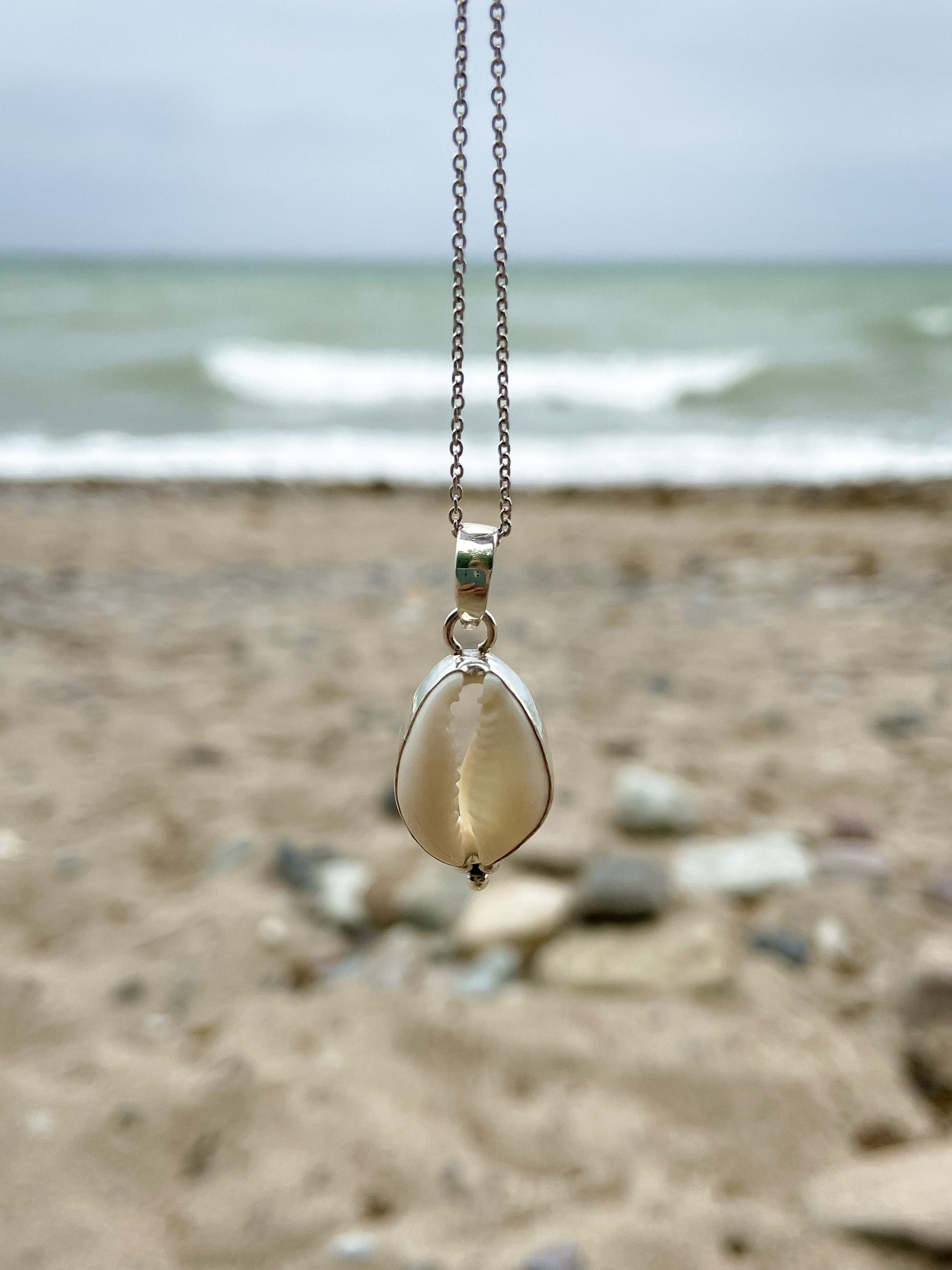 Kette mit Kaurimuscheln am Meer