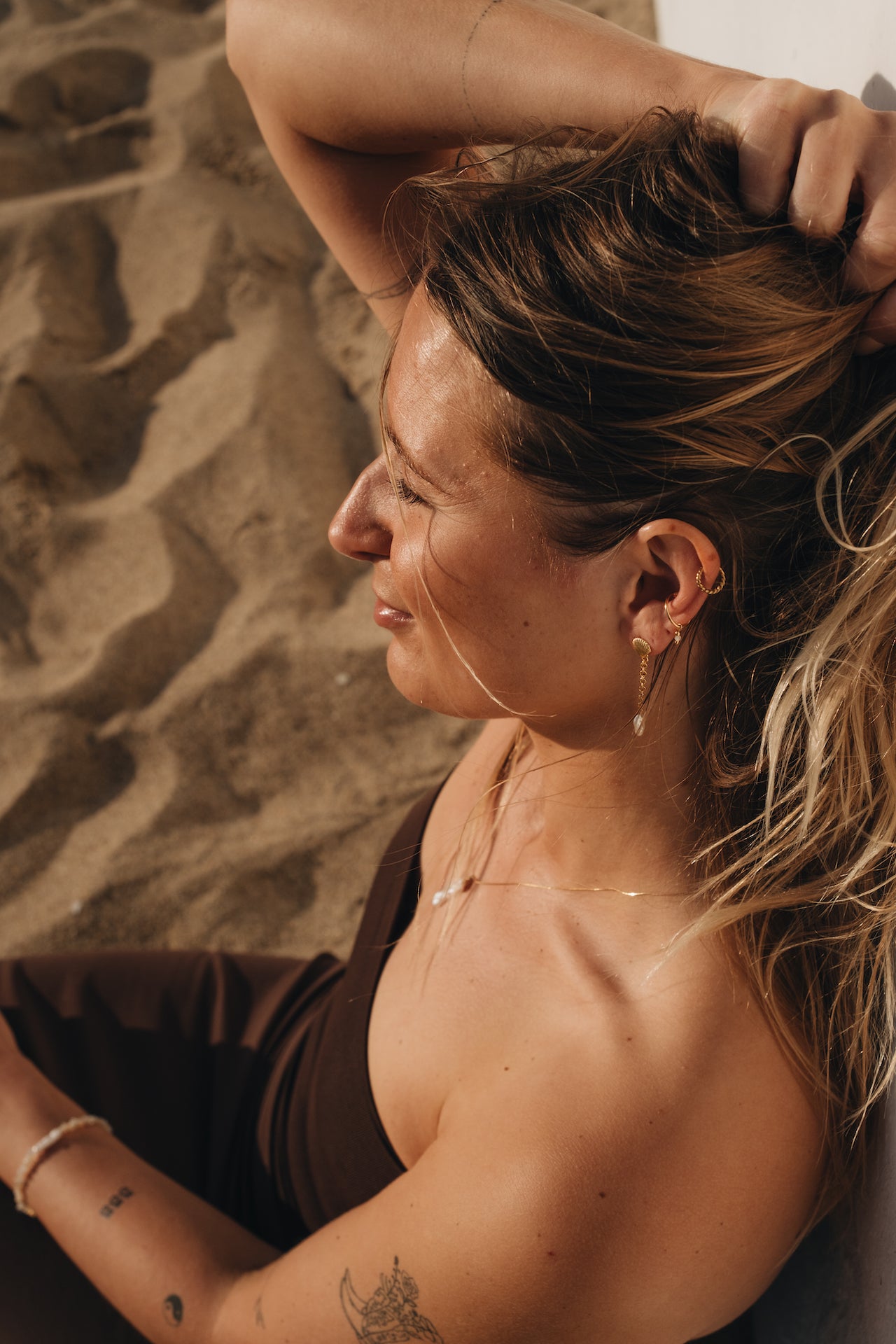 Earcuff BASIC INTUITION mit Mondsteinperle getragen von weiblichen Model am Strand